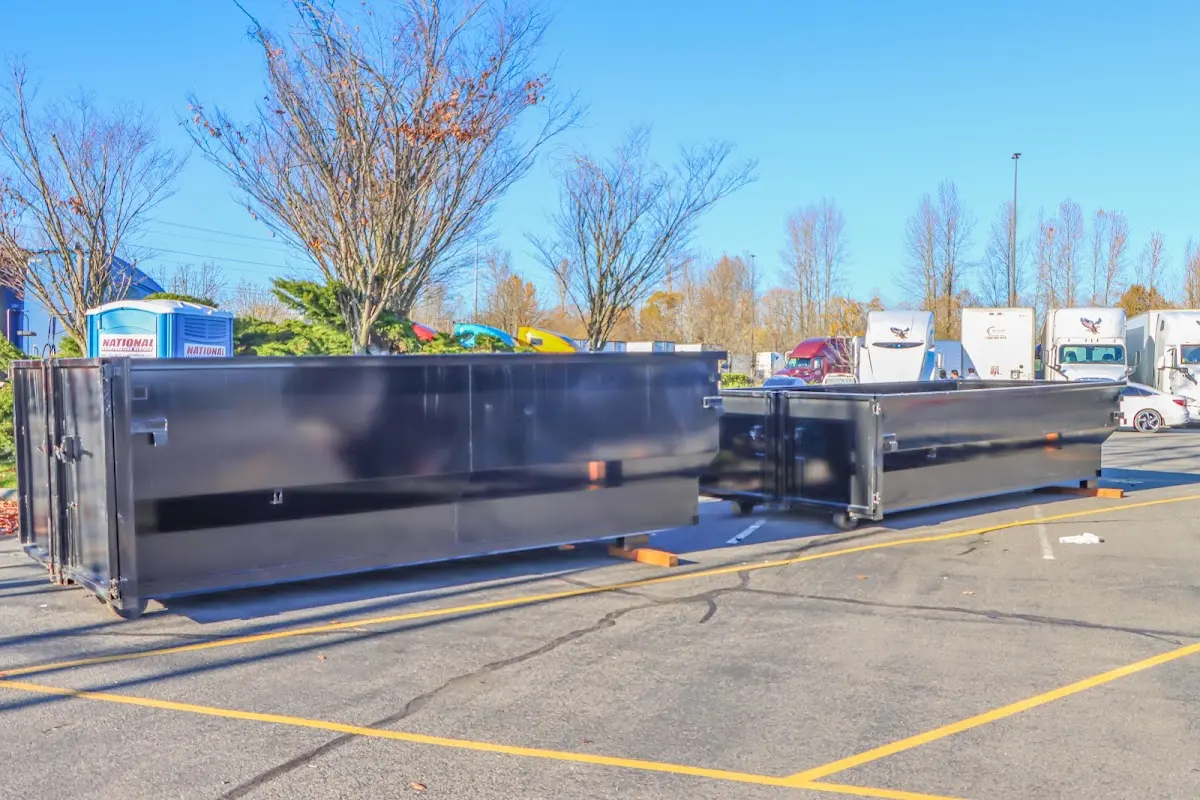 Professional dumpster rental service with roll-off container on residential driveway in Aztec